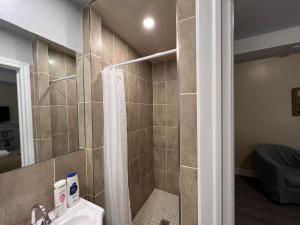 a bathroom with a shower with a toilet and a sink at Bauer Guesthouse in Toronto