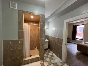 a bathroom with a shower with a glass door at Bauer Guesthouse in Toronto