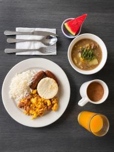 a table with a plate of food with rice and a cup of coffee at Hotel Doral Inn in Ibagué
