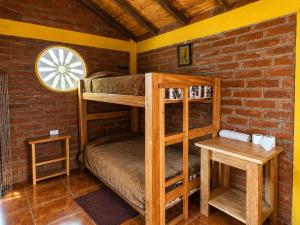 a room with bunk beds in a brick wall at Hostal el Vaquero in Chugchilán
