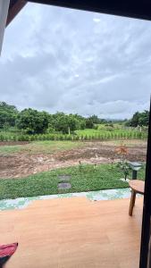 a view of a field from a window at บ้านสวนแม่จันทร์เพ็ญ in Chiang Dao