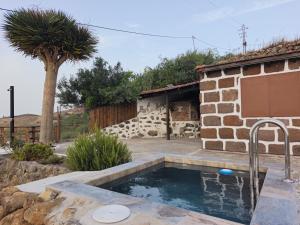 a pool in a yard next to a house at Finca Cho Rafael in Gáldar