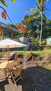 a table and two chairs and an umbrella at Bale Sunset Inn in Senaru