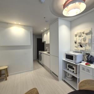 a kitchen with white cabinets and a microwave at Stay in Seoul, 3 min to Seoul Station, New Apt, 3 Air Conditioners, Elevator, Rooftop, Quiet & Cozy in Seoul