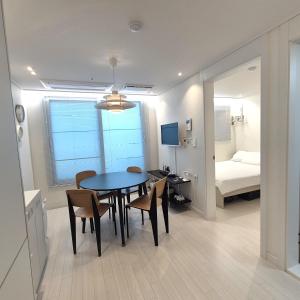 a room with a table and chairs and a bedroom at Stay in Seoul, 3 min to Seoul Station, New Apt, 3 Air Conditioners, Elevator, Rooftop, Quiet & Cozy in Seoul