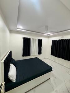 a bed in a room with black and white marble floors at Prince Villa in Neral