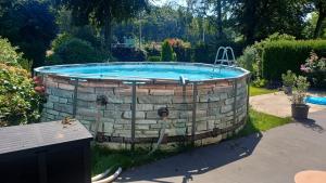 a swimming pool in a yard with a brick wall at Rikes Ferienwohnung 2 in Heinsberg