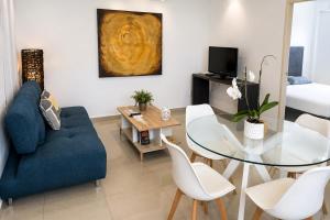 a living room with a blue couch and a glass table at Magico s apartments in Playa del Carmen