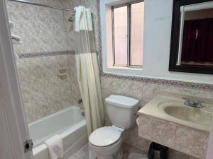 a bathroom with a toilet and a sink at Penguin Motel in Harbor City +8 photos