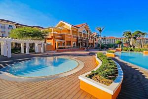 a resort with a large swimming pool next to a building at 2BR Condo with pool at Sorrento Oasis Pasig in Manila +13 photos