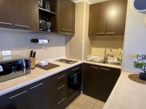 a kitchen with brown cabinets and a sink at Hermoso depto. con estacionamiento in Los Ángeles