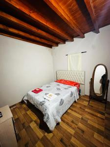 a bedroom with a bed and a mirror in it at Salvita Hospedaje y Excursiones in El Peñón