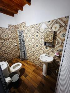 a bathroom with a toilet and a sink at Salvita Hospedaje y Excursiones in El Peñón