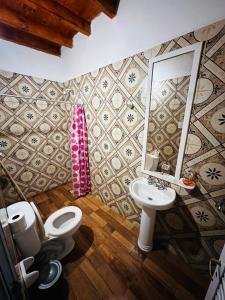 a bathroom with a toilet and a sink and a mirror at Salvita Hospedaje y Excursiones in El Peñón