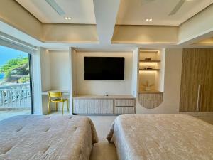 a bedroom with a flat screen tv and a bed at Suite Deluxe frente al Mar - Playa & GYM in Acapulco