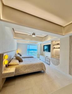 a large bedroom with a bed and a view of the ocean at Suite Deluxe frente al Mar - Playa & GYM in Acapulco