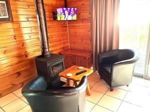 a living room with two chairs and a stove at Lumera Eco Chalets in Saint Marys