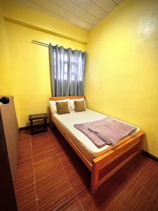 a bedroom with a bed in a yellow room at 2 Bedrooms with free parking in Baguio