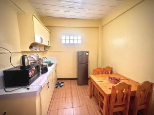 a small kitchen with a table and a refrigerator at 2 Bedrooms with free parking in Baguio