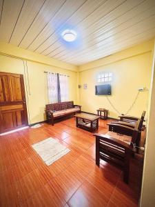a living room with wooden floors and a flat screen tv at 2 Bedrooms with free parking in Baguio