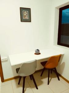 a white desk with two chairs in a room at Casa de Cima in Doze Ribeiras