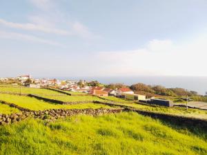 a view of a field with houses and a city at Casa de Cima in Doze Ribeiras
