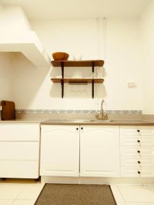 a kitchen with white cabinets and a sink at Casa de Cima in Doze Ribeiras
