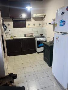 a kitchen with a white refrigerator and a stove at disfruta tu estadía in Salto +10 photos