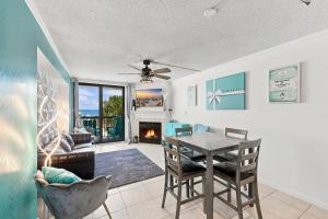 a living room with a table and chairs and a fireplace at Beachfront Bliss 3BR Oceanfront Condo with Pool and Hot Tub in Myrtle Beach