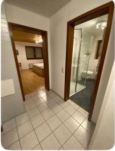 a room with a bathroom with a mirror and a shower at Ferienwohnung am Rande des Rothaarsteigs in Kreuztal +5 photos