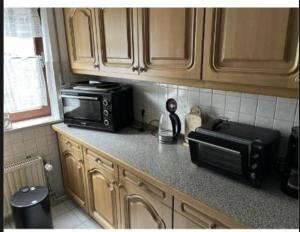 a kitchen with a counter top with a microwave and a counter sidx sidx at Ferienwohnung am Rande des Rothaarsteigs in Kreuztal