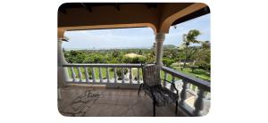 a balcony with a chair looking out at the trees at Ocean veiw Apartment in Telescope
