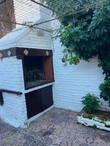 a white brick building with a dog house at disfruta tu estadía in Salto