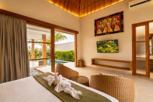 a bedroom with a bed and a view of a pool at Arta Private Villa in Ubud +21 photos