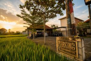 a sign in front of a field of grass at Arta Private Villa in Ubud