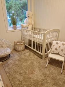 ein Babybett mit einem Teddybären in einem Zimmer in der Unterkunft Løten in Løten