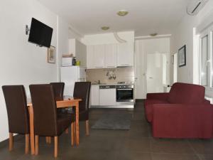 a kitchen and living room with a table and a red couch at Apartments Despot Zaostrog RC in Zaostrog