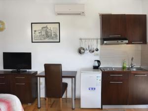 a kitchen with a sink and a table and a kitchen with a refrigerator at Apartments Despot Zaostrog RL in Zaostrog