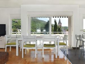 a dining room with a table and chairs and a large window at Apartments Despot Zaostrog RR in Zaostrog