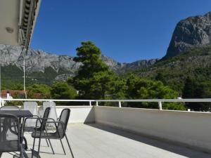 a table and chairs on a balcony with mountains at Apartments Despot Zaostrog RR in Zaostrog