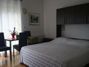 a bedroom with a bed and a table and a window at Apartments Despot Zaostrog RO in Zaostrog +4 photos
