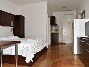 a bedroom with a bed and a kitchen with a refrigerator at Apartments Despot Zaostrog RO in Zaostrog