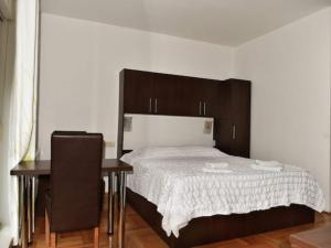 a bedroom with a bed and a table and a desk at Apartments Despot Zaostrog RO in Zaostrog