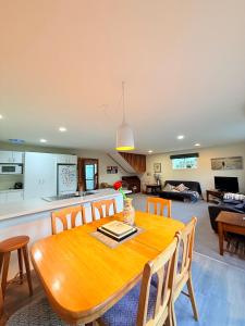 a kitchen and dining room with a wooden table and chairs at Cozy Escape in Wanaka