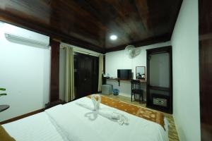 a bedroom with a bed with a towel on it at KhounPhet Hotel in Luang Prabang +25 photos