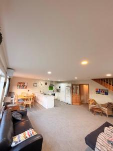 a living room with a couch and a kitchen at Cozy Escape in Wanaka