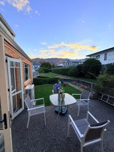a patio with a white table and chairs and a table at Cozy Escape in Wanaka