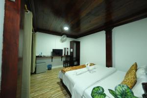 a bedroom with a bed and a desk in a room at KhounPhet Hotel in Luang Prabang