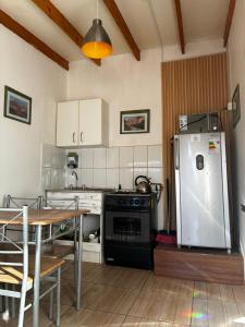 a kitchen with a stove and a refrigerator and a table at Tambo Norte in San Pedro de Atacama