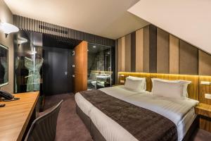 a bedroom with a large bed and a desk and a desk at All Seasons Residence Hotel in Sofia